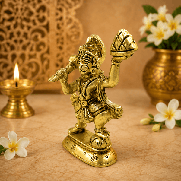 Golden Hanuman idol holding a mountain on a raised hand, side view