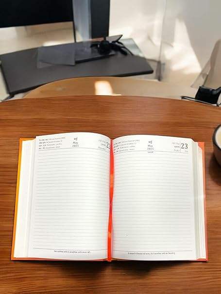 Open diary with ruled date pages and red binding, showing '23' marker