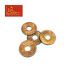Set of copper coins with ornate patterns and round center holes, flat metal discs