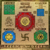 Gold yantra chart with central red mandala and blue, green, and yellow decorative blocks.