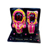 Marble dust idol statue with two standing faces, decorated in pink, yellow, and dark base
