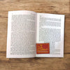 Open hardcover book with printed text pages and a red title label on right page