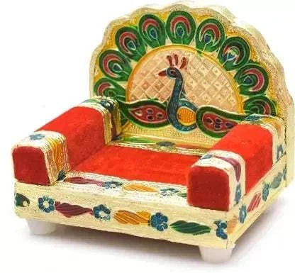 Peacock design wooden singhasan with red cushioned seat, carved sides, and gold-green back
