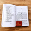 Open paperback with dense printed pages and red emblem cover graphic