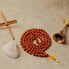 Brown rudraksha bead mala with gold-toned tassel and pendant clasp