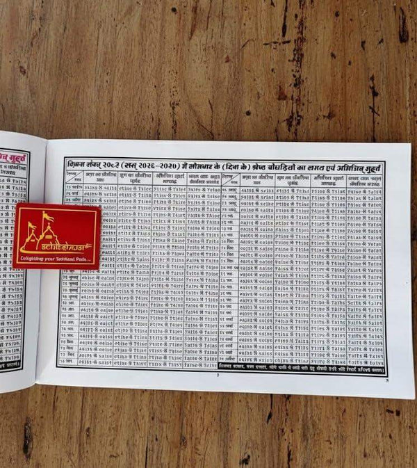 Panchang book with open pages showing rows of dates and astrological tables