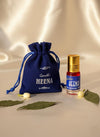 Blue drawstring pouch and gold roll-on attar bottle labeled Heena, with leaves