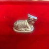 Metallic Nandi bull figurine with raised patterned body and head, small stand base