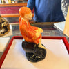 Sai Baba statue idol with orange robe and folded hands on dark pedestal base