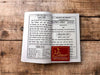 Open book with dense printed text pages and central logo on right page.