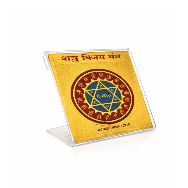 Shatru Vijay Yantra plaque on clear stand, gold with red-blue emblem